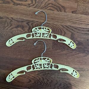 2 yellow plastic vintage child’s clothing hangers with‎ circus theme